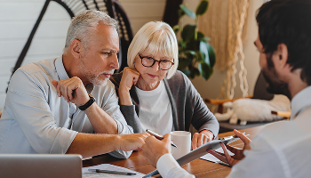 A man is conversing with an older couple